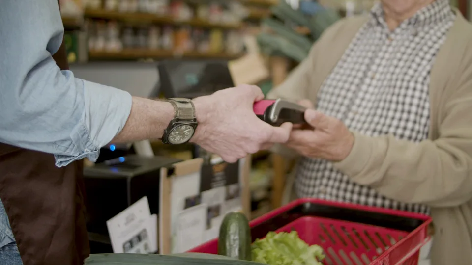 A customer paying by card at a grocery store checkout